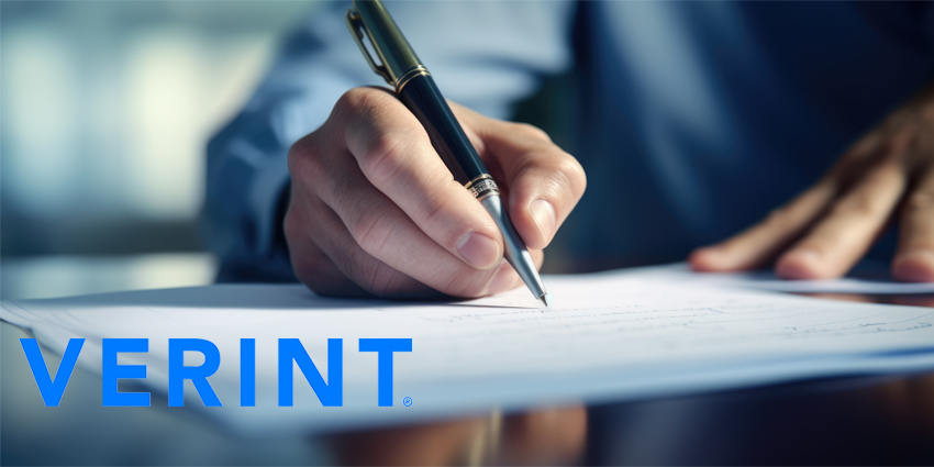 Close-up of a person's hand holding a pen and signing a document, suggesting a business or legal agreement.